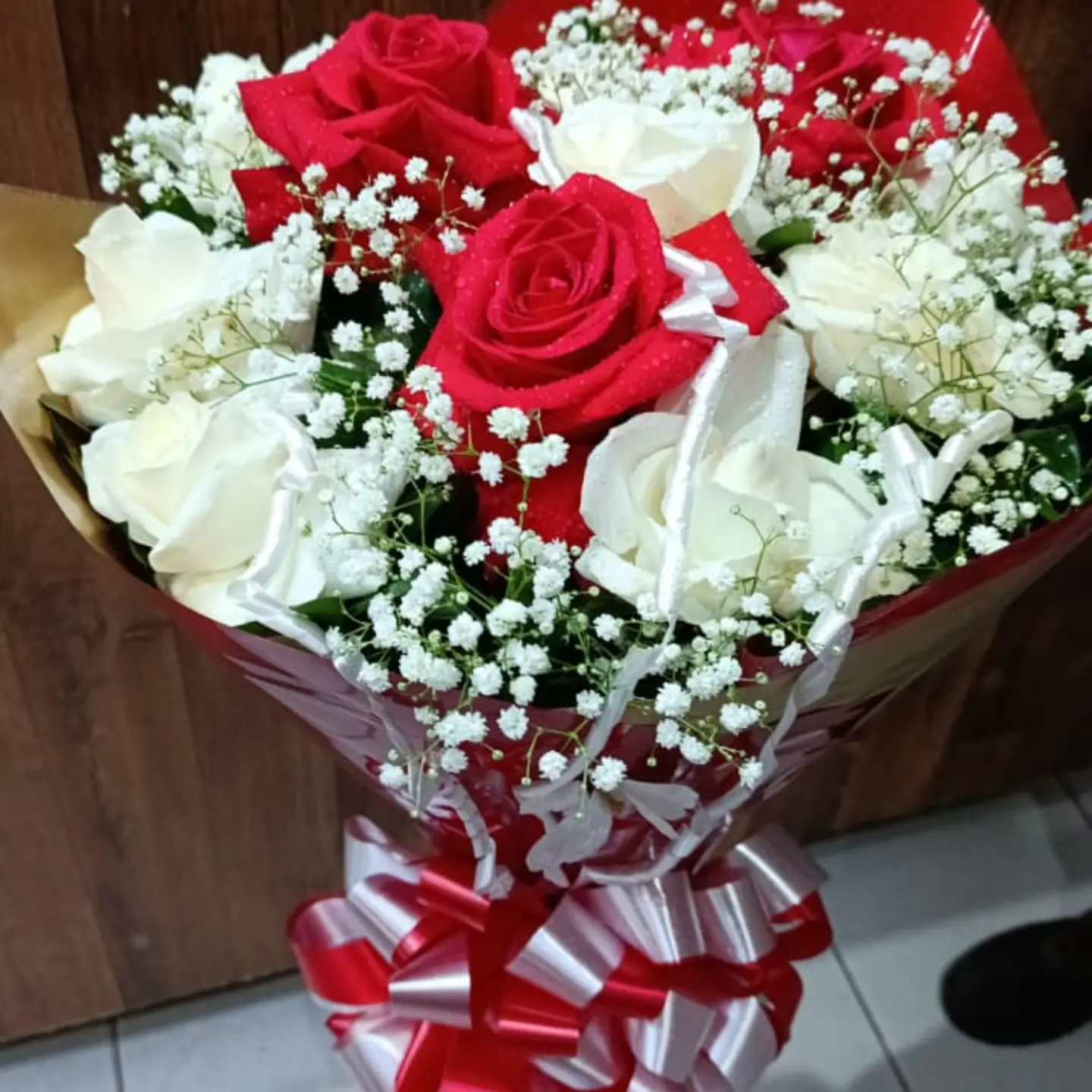 Buquê de rosas vermelhas e brancas com laço de cetim vermelho