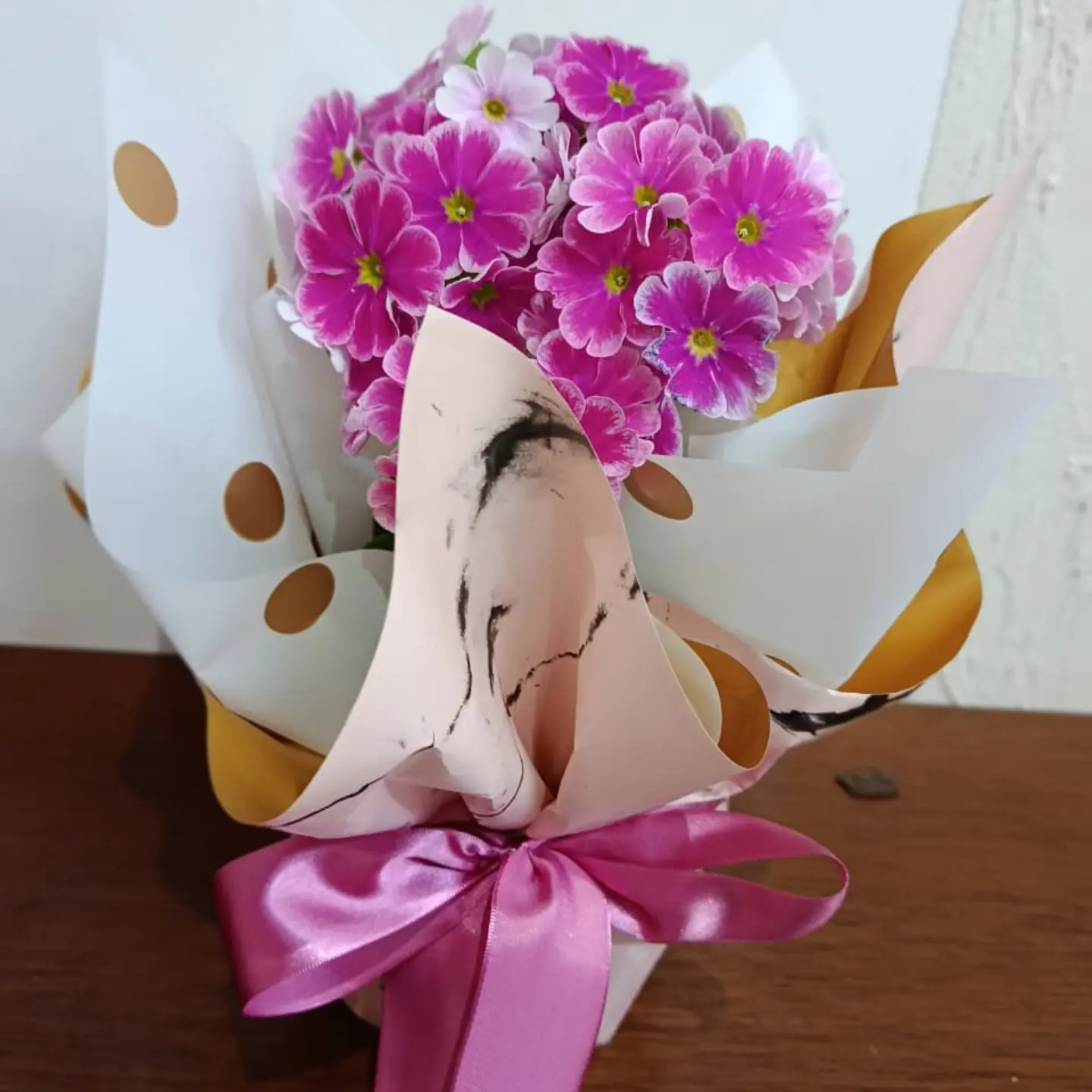 Primaveras rosas em embalagem branca e dourada